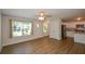 Bright living room flows into kitchen, featuring stainless steel appliances, an island, and wood flooring at 5350 Mercedes Dr, Cumming, GA 30041