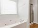 Bright bathroom with a soaking tub, large window, and glass shower door at 1269 Gates Se Cir, Atlanta, GA 30316