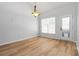 Sunlit dining room with hardwood floors, stylish light fixture, and glass door to the backyard at 1269 Gates Se Cir, Atlanta, GA 30316