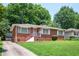 Charming brick home featuring a well-maintained front yard and a cozy entrance with red painted stairs and white railings at 2581 N Clark Dr, Atlanta, GA 30344