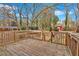 Wooden backyard deck with railings overlooks the yard with mature trees, shed and trampoline at 4138 Hickory Dr, Powder Springs, GA 30127