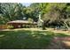 Scenic view of the backyard with a lush lawn, playset, fire pit, and mature trees at 4138 Hickory Dr, Powder Springs, GA 30127