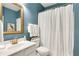This clean bathroom has a white sink, toilet, shower with blue walls at 4140 Prince Charles Dr, Duluth, GA 30097