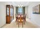 Formal dining room showcasing a dark wooden cabinet, a table set for six, and a tray ceiling at 4140 Prince Charles Dr, Duluth, GA 30097