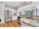 Open kitchen featuring stainless steel appliances, granite countertops, and hardwood floors with ample storage at 4140 Prince Charles Dr, Duluth, GA 30097