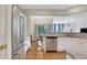 Stylish kitchen featuring stainless steel appliances, white cabinetry, stone counters, and open layout to dining area at 4140 Prince Charles Dr, Duluth, GA 30097