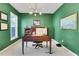 Home office with dark green walls, wooden desk, plush carpeting and a bright window at 4140 Prince Charles Dr, Duluth, GA 30097