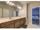 Bright bathroom with double vanity sinks, granite countertops, and wooden cabinets at 5540 Wood Falls Dr, Buford, GA 30518