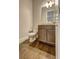 Powder room with wood floors, granite countertop, and vanity at 5540 Wood Falls Dr, Buford, GA 30518