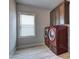 Bright laundry room featuring modern machines, window, and overhead storage at 5540 Wood Falls Dr, Buford, GA 30518