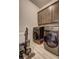 Laundry room with washer, dryer, cabinets, and tile floor at 5540 Wood Falls Dr, Buford, GA 30518