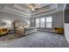 Spacious main bedroom with tray ceiling, carpet floors and large windows at 5540 Wood Falls Dr, Buford, GA 30518
