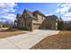 Brick home with a three-car garage and wide concrete driveway at 5540 Wood Falls Dr, Buford, GA 30518