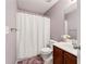 Bathroom featuring a shower, toilet, wood vanity and sink with purple accent wall at , Conyers, GA 30012