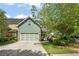 A two car garage with driveway and a large tree in the front yard at , Conyers, GA 30012