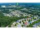 An aerial view of a neighborhood with mature trees with a lake and retail including Walmart and Kroger nearby at 213 Roseman Way, Woodstock, GA 30188