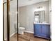 A bathroom featuring a glass door shower and vanity with blue cabinets at 213 Roseman Way, Woodstock, GA 30188