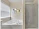 This bathroom features a soaking tub with a window and separate glass shower stall at 213 Roseman Way, Woodstock, GA 30188