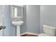 Powder room featuring a pedestal sink, toilet, and stylish decor at 213 Roseman Way, Woodstock, GA 30188