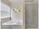 Close up of a modern bathroom featuring a large tub and a glass-enclosed shower at 213 Roseman Way, Woodstock, GA 30188