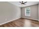 An interior view of a bedroom featuring hardwood floors, a ceiling fan, and window at 213 Roseman Way, Woodstock, GA 30188