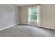 Empty bedroom with window, carpet and decorative wallpaper at 213 Roseman Way, Woodstock, GA 30188