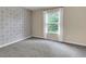 Small bedroom showcases a decorative accent wall and a window for natural light at 213 Roseman Way, Woodstock, GA 30188