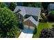 Aerial view of the home's exterior with a well-manicured lawn and mature trees at 213 Roseman Way, Woodstock, GA 30188
