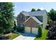 Charming two-story home featuring a brick facade, two-car garage, and a well-manicured lawn at 213 Roseman Way, Woodstock, GA 30188