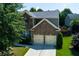 Charming two-story home featuring a brick facade, two-car garage, and a well-manicured lawn at 213 Roseman Way, Woodstock, GA 30188