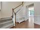 Bright foyer featuring hardwood floors, a staircase with white railings, and a decorative bench at 213 Roseman Way, Woodstock, GA 30188