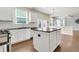 Bright kitchen with an island with granite countertops and white cabinets at 213 Roseman Way, Woodstock, GA 30188