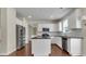 Bright kitchen features white cabinets, stainless steel appliances, and an island with dark countertops at 213 Roseman Way, Woodstock, GA 30188