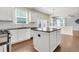 Open kitchen with white cabinetry, granite counters, and a center island for food preparation at 213 Roseman Way, Woodstock, GA 30188