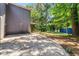 Back of home featuring driveway, ample greenery, and a charming blue storage shed in backyard at 3617 Lassiter Rd, Marietta, GA 30062