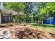 Expansive backyard showcasing a covered deck, blue storage shed, and a cozy fire pit area at 3617 Lassiter Rd, Marietta, GA 30062