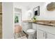 Bright bathroom featuring a double vanity, wood-look tile floors, and an open doorway at 3617 Lassiter Rd, Marietta, GA 30062