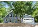 Charming blue home with attached garage and mature trees in the front yard at 3617 Lassiter Rd, Marietta, GA 30062