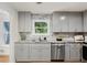 Updated kitchen design featuring gray cabinets, stainless appliances, and granite countertops at 3617 Lassiter Rd, Marietta, GA 30062