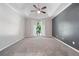 Bright bedroom featuring a tray ceiling, modern ceiling fan, neutral color palette, and a large arched window at 3793 Market Cres, Clarkston, GA 30021