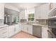 Modern kitchen features white cabinetry, stainless steel appliances, and granite countertops with a bright window at 3793 Market Cres, Clarkston, GA 30021