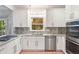 Modern kitchen features white cabinets, stainless steel appliances, and granite countertops with a bright window at 3793 Market Cres, Clarkston, GA 30021