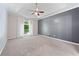 Spacious Primary bedroom with a tray ceiling, large window, and neutral carpet, creating a serene retreat at 3793 Market Cres, Clarkston, GA 30021
