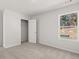 Bedroom featuring neutral carpet, trim, closet, and a window with a view of trees at 915 Sundown Pt, Villa Rica, GA 30180