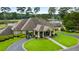 Inviting golf clubhouse with an American flag, covered entrance, golf carts and lush landscape at 915 Sundown Pt, Villa Rica, GA 30180