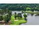 Picturesque golf course view featuring a sand trap, lush green, and bridge over a serene lake at 915 Sundown Pt, Villa Rica, GA 30180