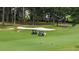 Golf course view with sand traps, golfers in carts, and lush greenery in a serene setting at 915 Sundown Pt, Villa Rica, GA 30180