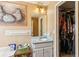 Small bathroom featuring a single sink vanity, a mirror, and a closet for storage at 60 Boardwalk Ave, Covington, GA 30016