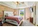 Relaxing main bedroom featuring a tray ceiling, neutral tones, an accent wall, and a window view at 60 Boardwalk Ave, Covington, GA 30016
