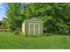 Charming shed in the backyard with green exterior and white trim at 60 Boardwalk Ave, Covington, GA 30016